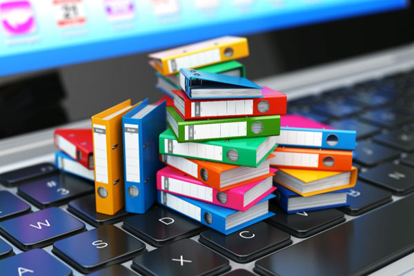 A stack of miniature books on top of a computer keyboard