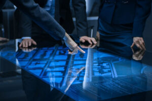 An image of men around a desk pointing at blue prints
