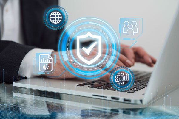 Image of a person using a laptop with shield and checkmark logos in the center of the screen